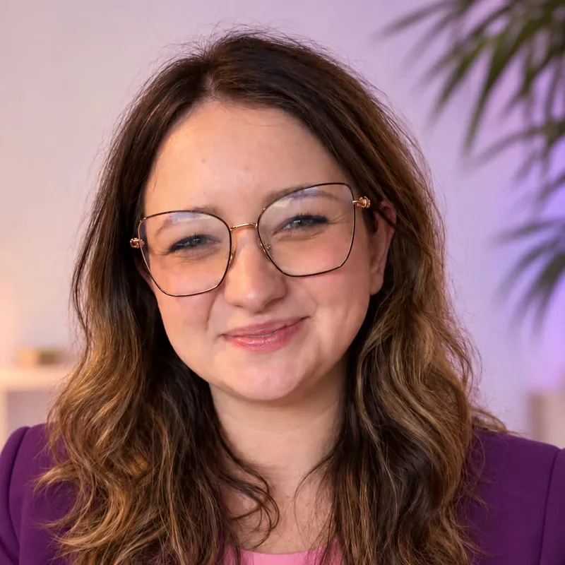 Karolina Michta, uśmiechnięta, w okularach i fioletowej marynarce